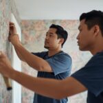 عمال يقومون بلسق ورق جدران