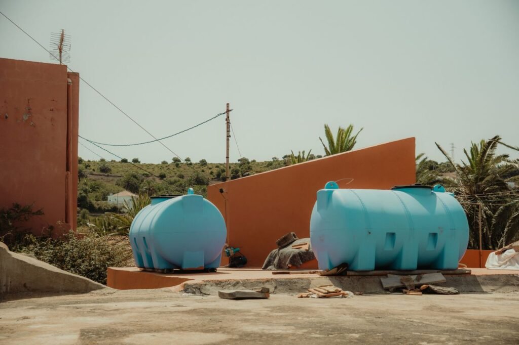 Bright blue tanks and rustic architecture in Las Hayas, Canarias, Spain under summer light.